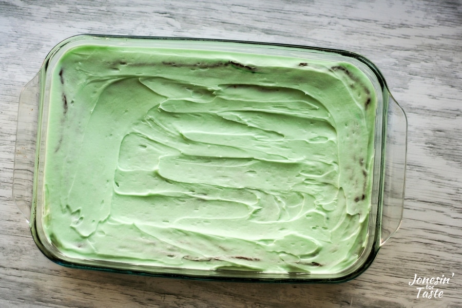 Mint brownies with the mint frosting spread on ready to be stuck in the freezer.