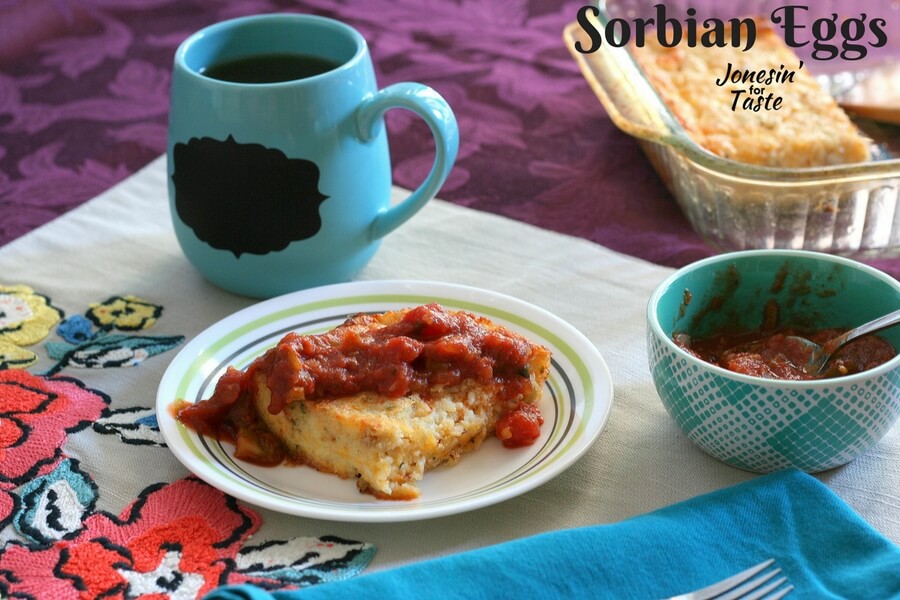 Sorbian Eggs on a table with a small blue bowl of salsa and the casserole dish in the background