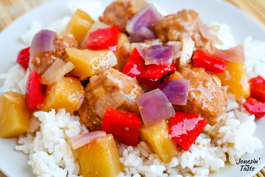 meatballs with chunks of peppers, onions, and pineapple over rice