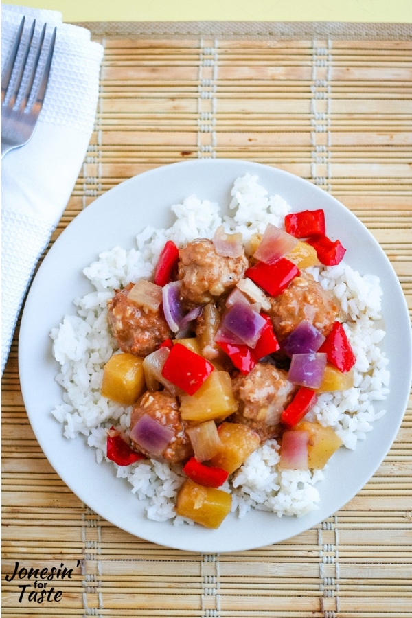 A plate of sweet and sour meatballs on a bamboo place mat