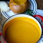 A red pot with pumpkin soup