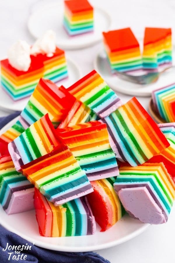 a pile of square rainbow jello slices on a plate