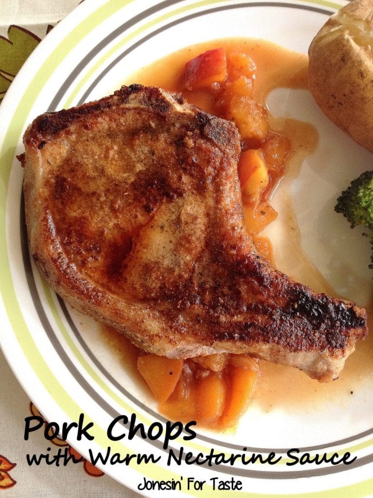 A pan fried pork chop over nectarine sauce on a plate.