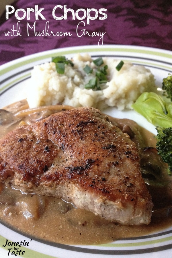 A purple tablecloth with a white plate filled with mashed potatoes topped with green onions, broccoli spears, and a pork chop lying on top of a pool of mushroom gravy.