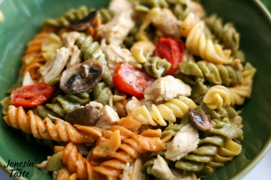 Tri-color pasta with pesto chicken, tomatoes, and mushrooms all tossed with alfredo sauce.