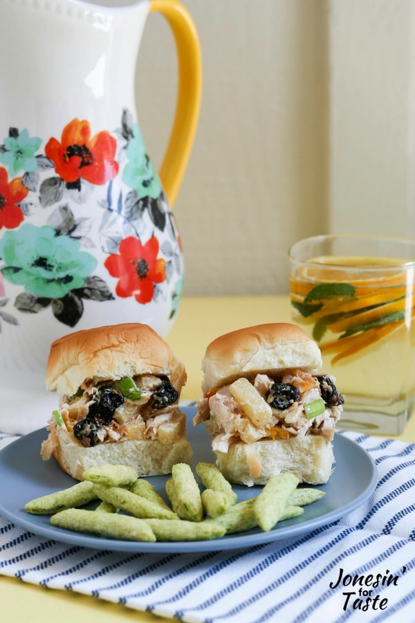 Tropical Chicken Salad sandwiches, snap pea crisps, and mint citrus water on a table.