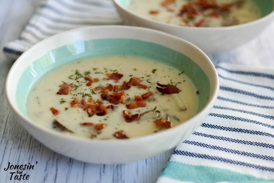 A bowl of potato bacon chowder topped with crisp chopped bacon and parsley