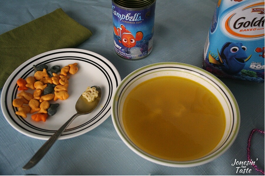 A bowl of soup and Goldfish crackers on a plate