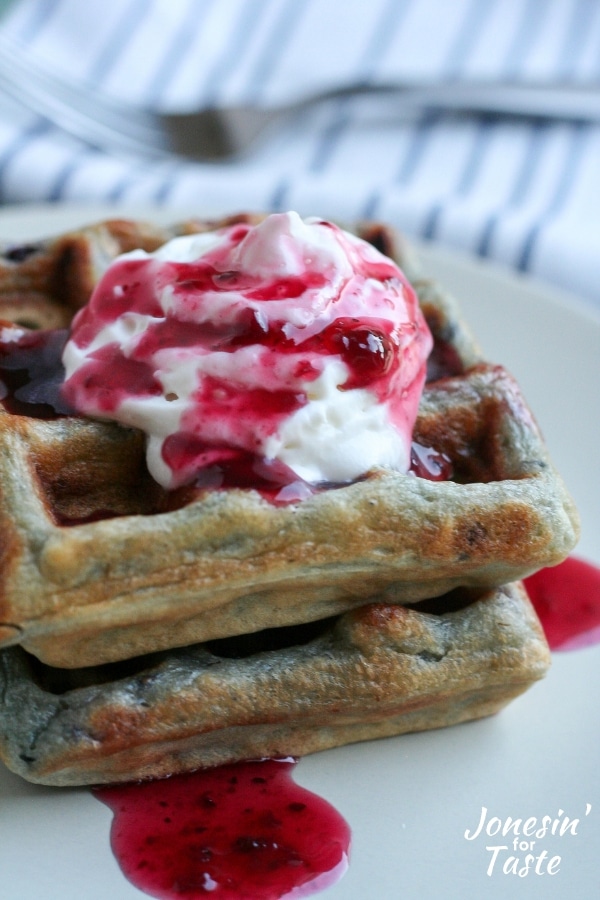 Blackberry waffles topped with whipped cream and syrup
