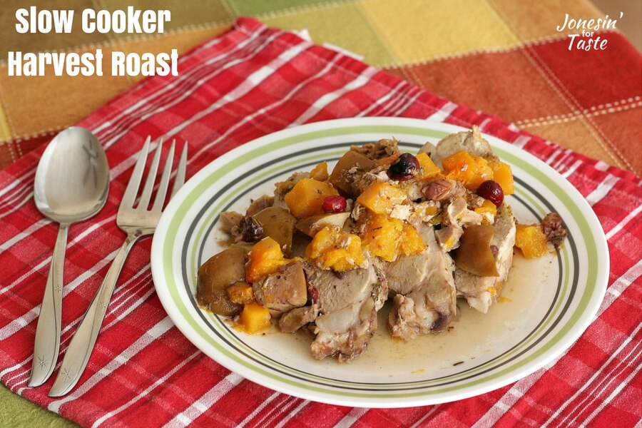 A plate of slow cooker harvest roast sliced and served up with the cooked squash, apples, and cranberries.