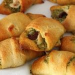 A pile of chicken croissants with pesto and sun dried tomato