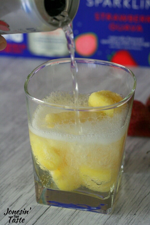 DASANI Sparkling being poured into a glass with frozen pineapple