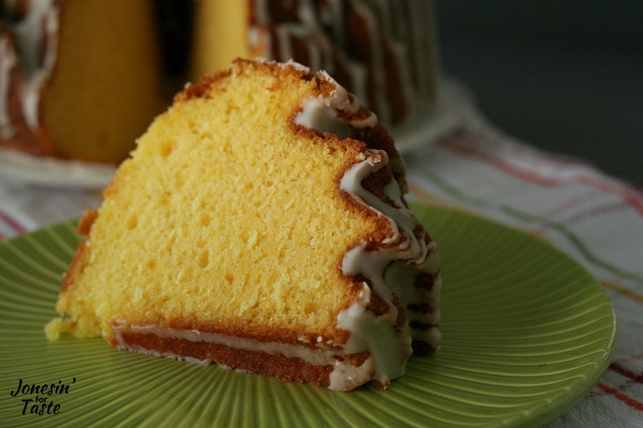 A slice of easy orange pound cake on a plate with drizzled icing on top
