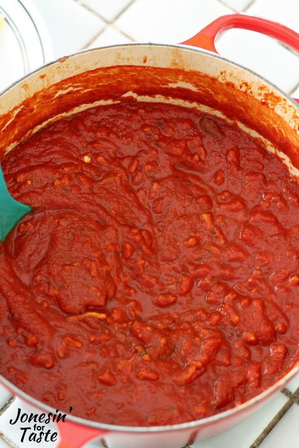 A large pot of Turkey Spaghetti Sauce with a blue ladle in the sauce.