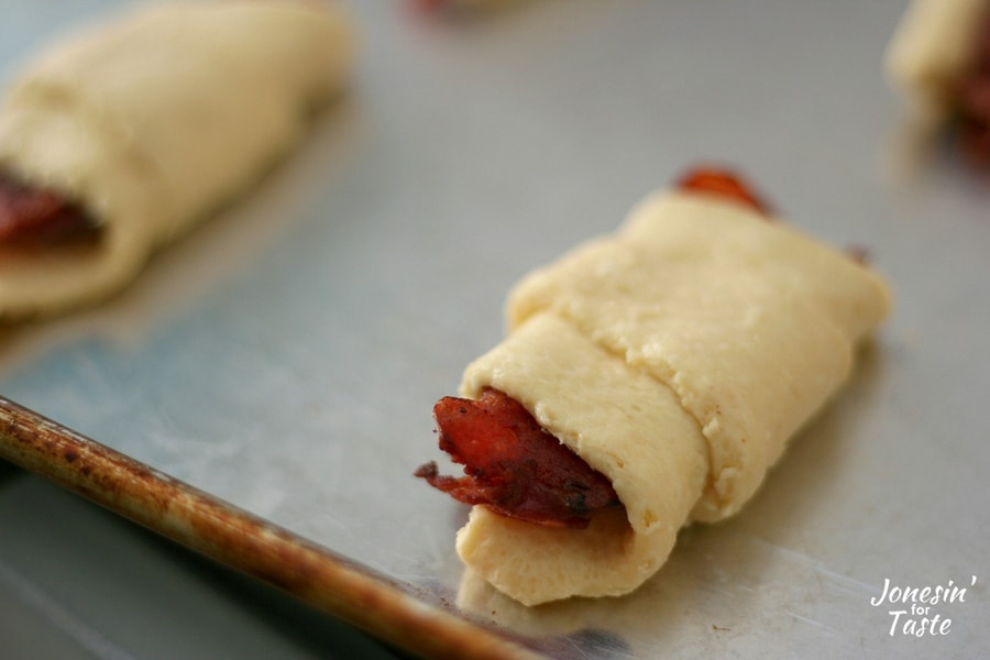 Uncooked easy bacon croissants on a cookie sheet ready to be put in the oven