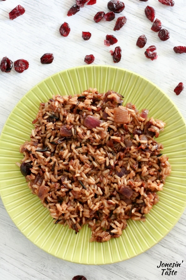Orange Cranberry Wild Rice on a green plate on a white wooden table.