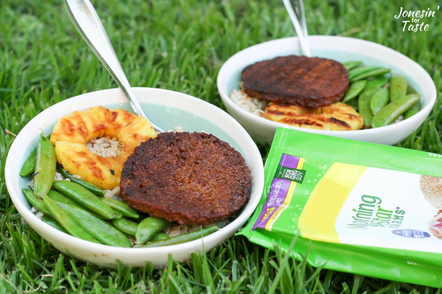 Two Teriyaki Veggie Burger Bowls and forks sitting on the grass