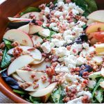 Spring salad mix topped with sliced apples, goat cheese crumbles, and bacon crumbles.
