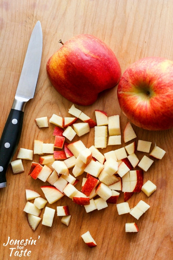 Diced apples and a knife on a cutting board