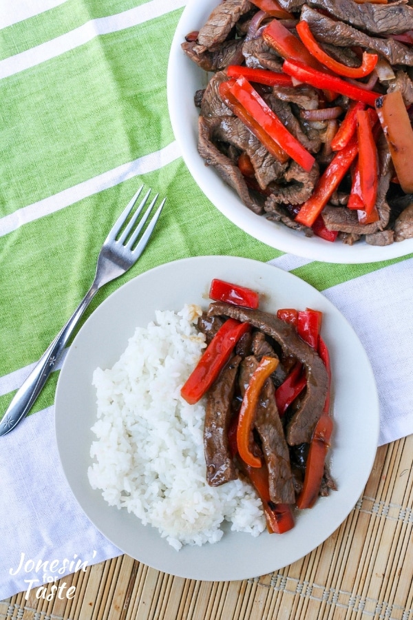 A plate and bowl of Asian pepper steak
