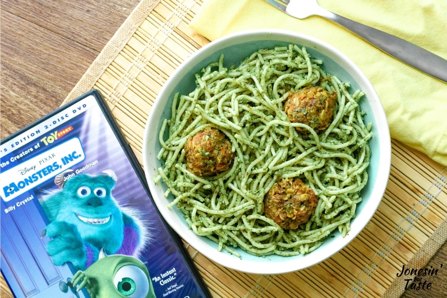 a bowl of pasta next to a monsters inc DVD