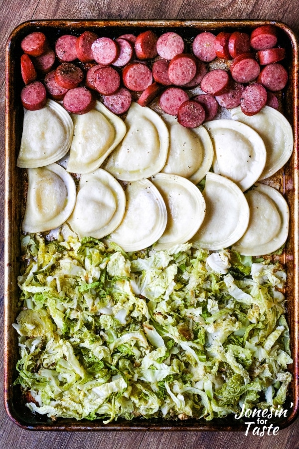 Rows of cooked sausages, pierogies, and oven roasted cabbage