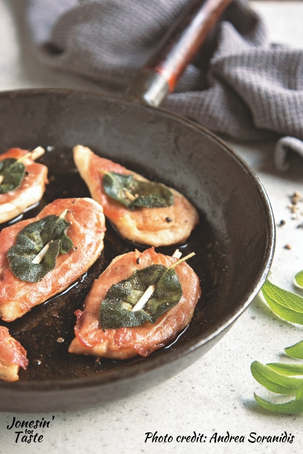 chicken saltimbocca in a black pan on a white counter