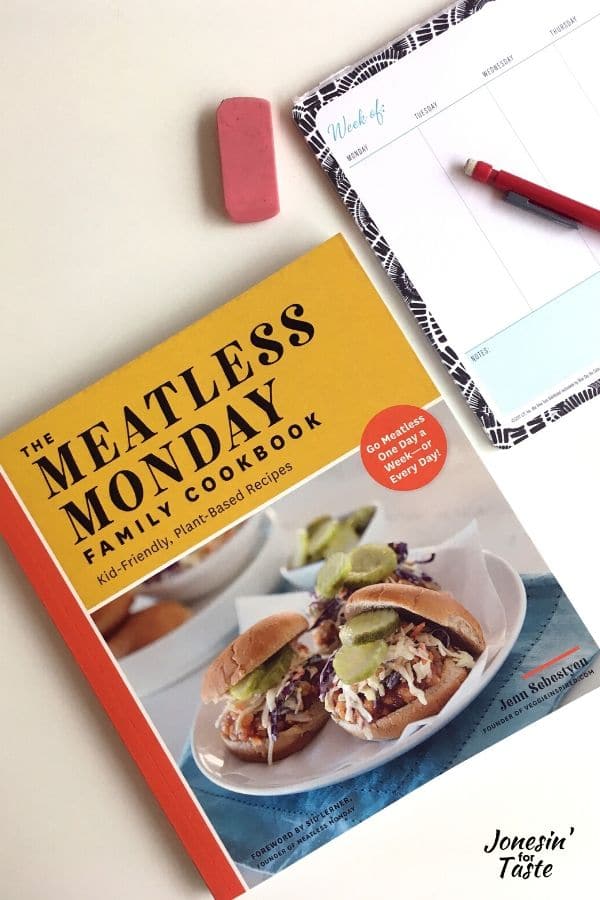 the meatless monday cookbook next to a meal planner