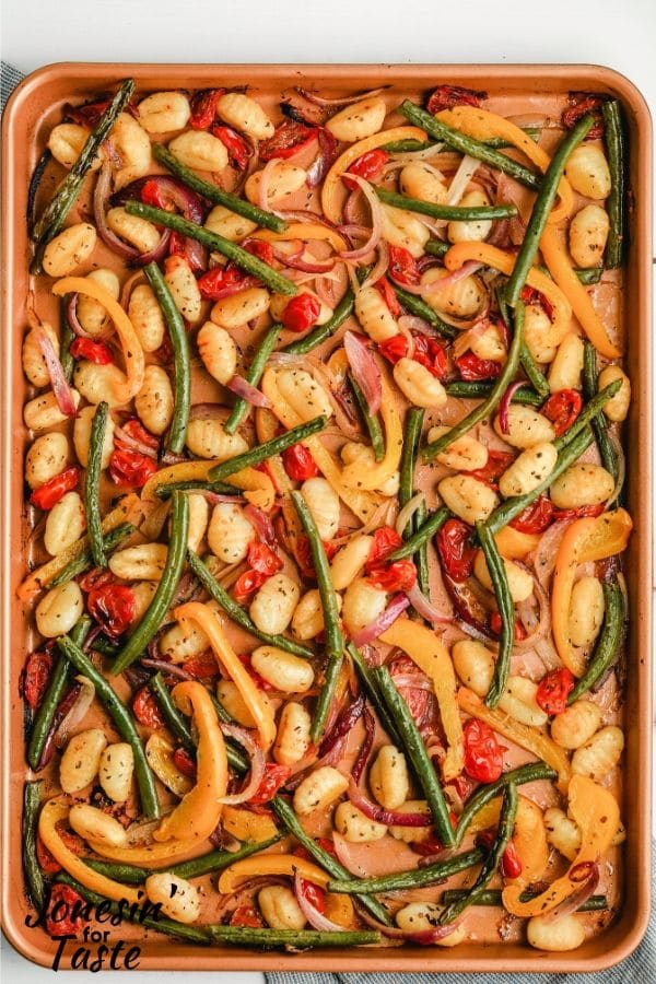 a cookie sheet with cooked gnocchi and veggies