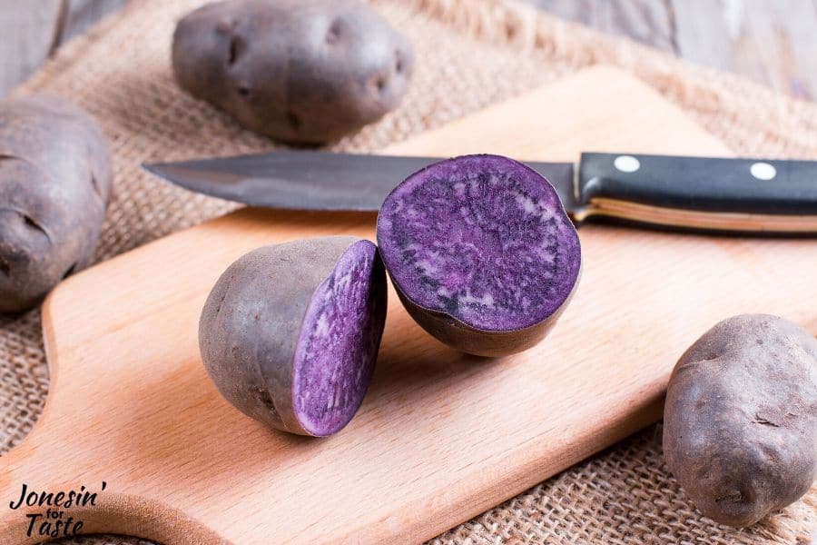 a purple potato cut in half on a cutting board