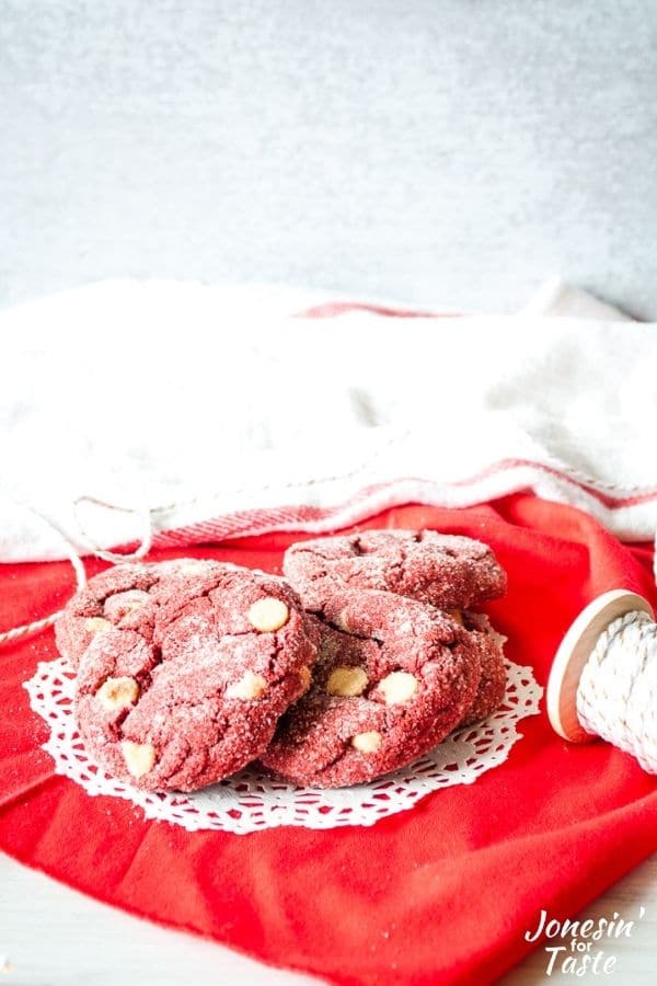 red velvet cookies on a doily on top of red fabric