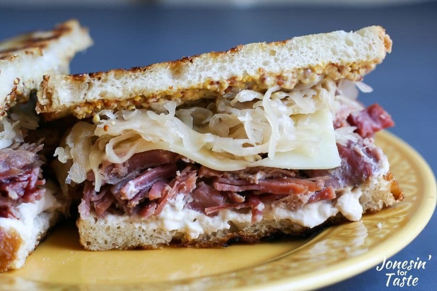 layers of sauerkraut, swiss cheese, and corned beef between slices of grilled sourdough bread